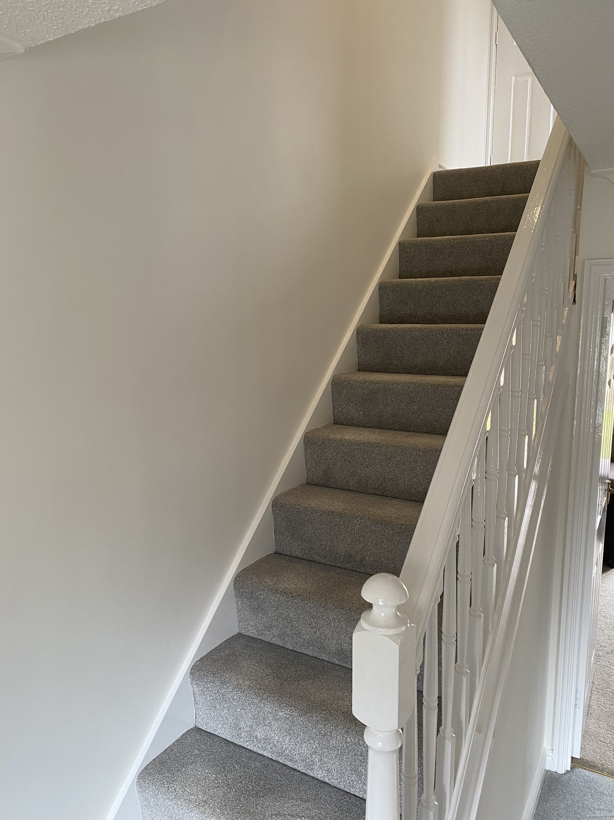 Bright white stairwell with painted spindles and newel post