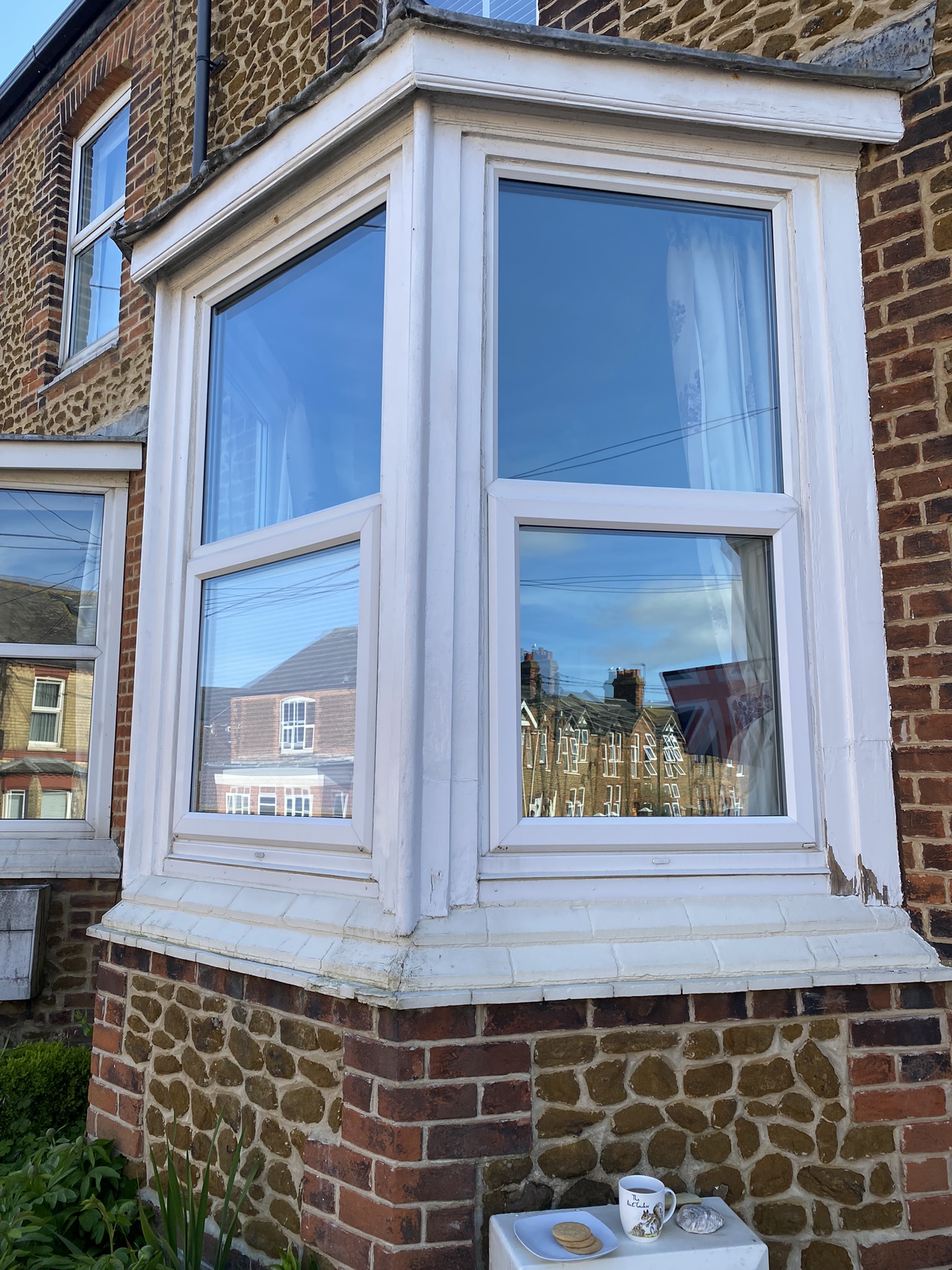 Freshly painted white bay window on a carrstone terrace
