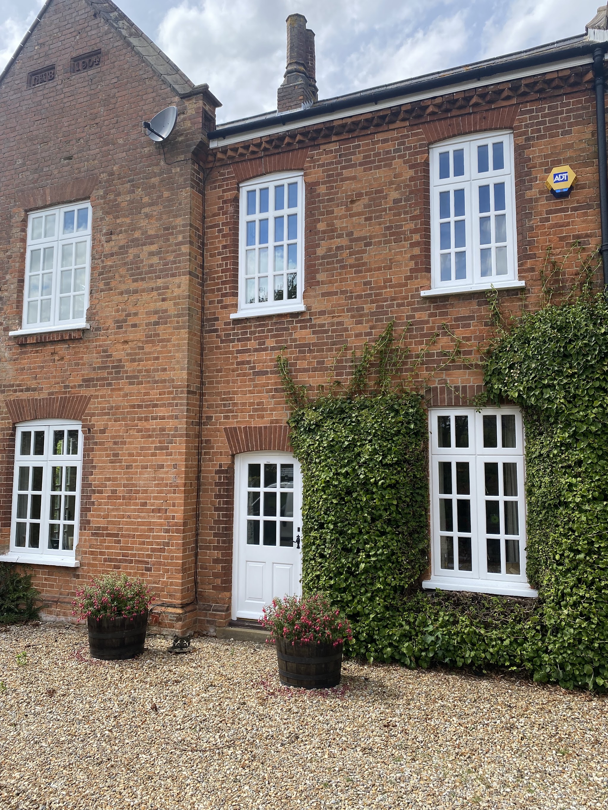 Red-brick house with freshly painted white sash windows and front door