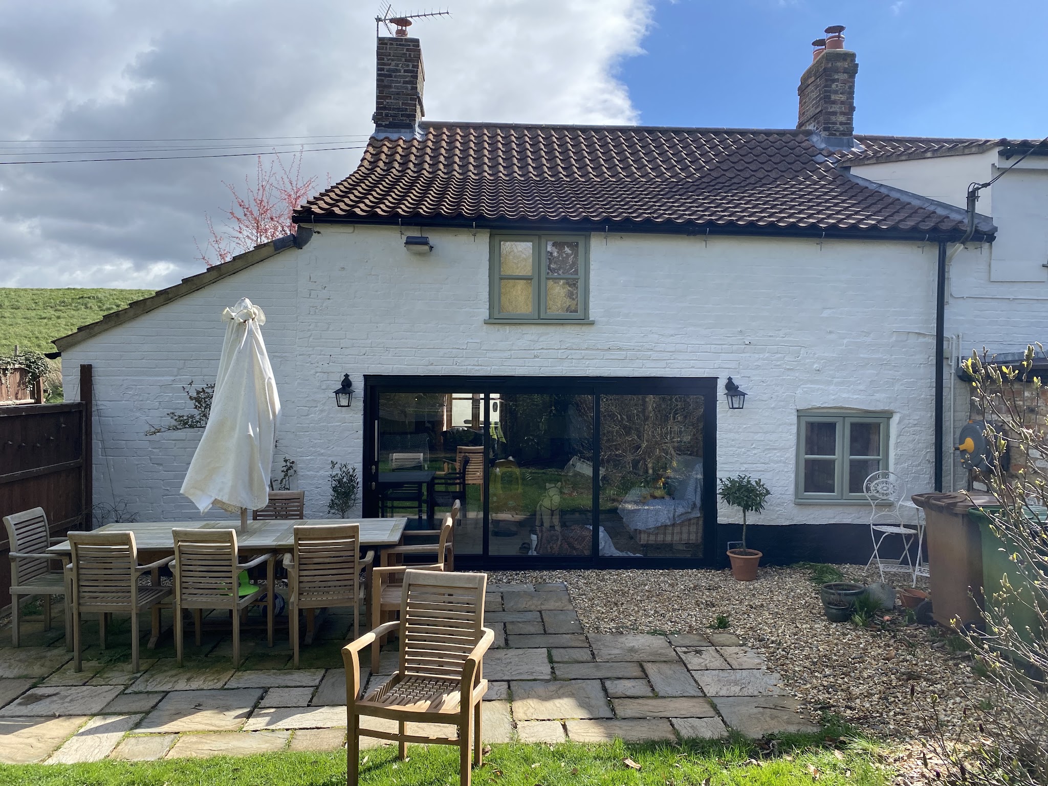 Whitewashed Norfolk cottage with pantile roof, patio and garden furniture