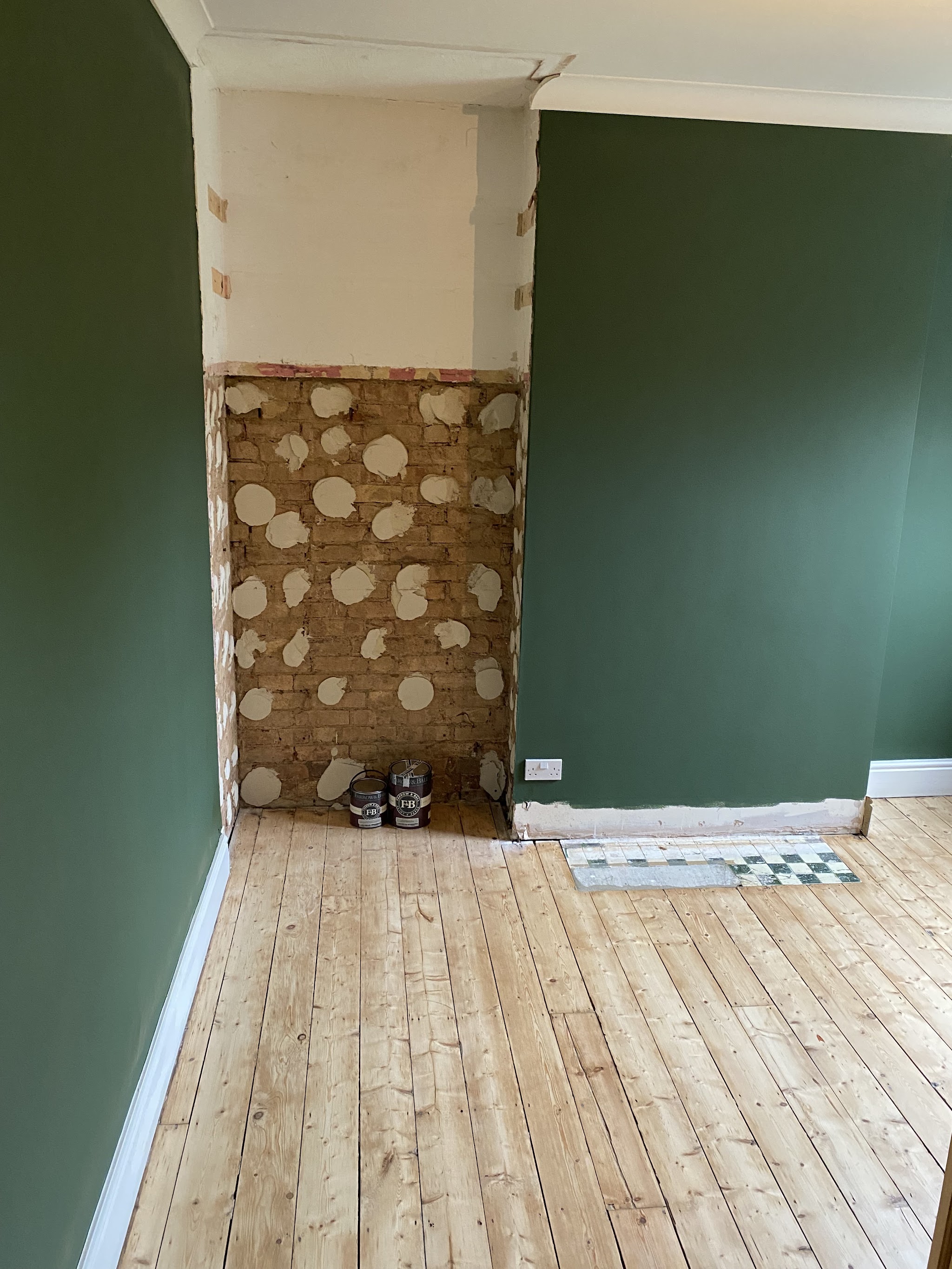 Deep green walls going on beside a chimney breast, mid-job