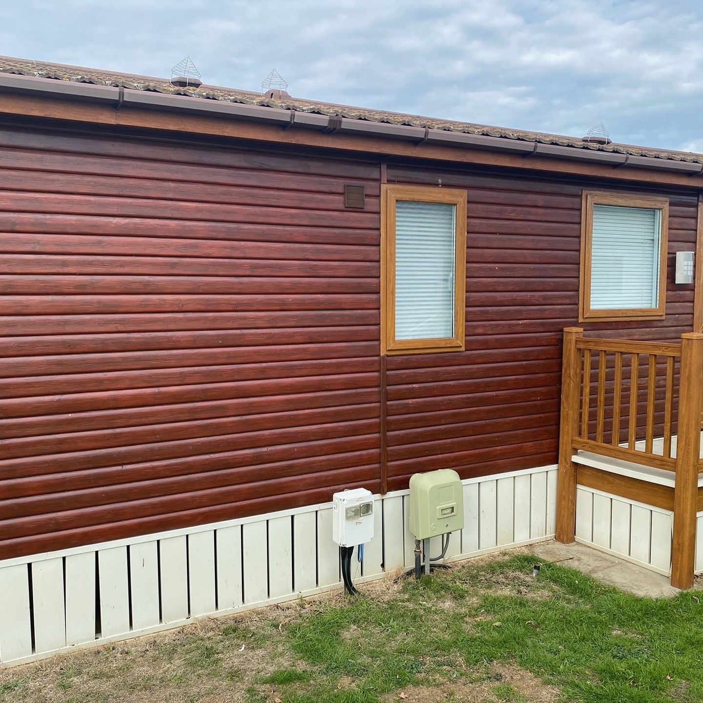 Timber lodge with deep red stained cladding and white boards